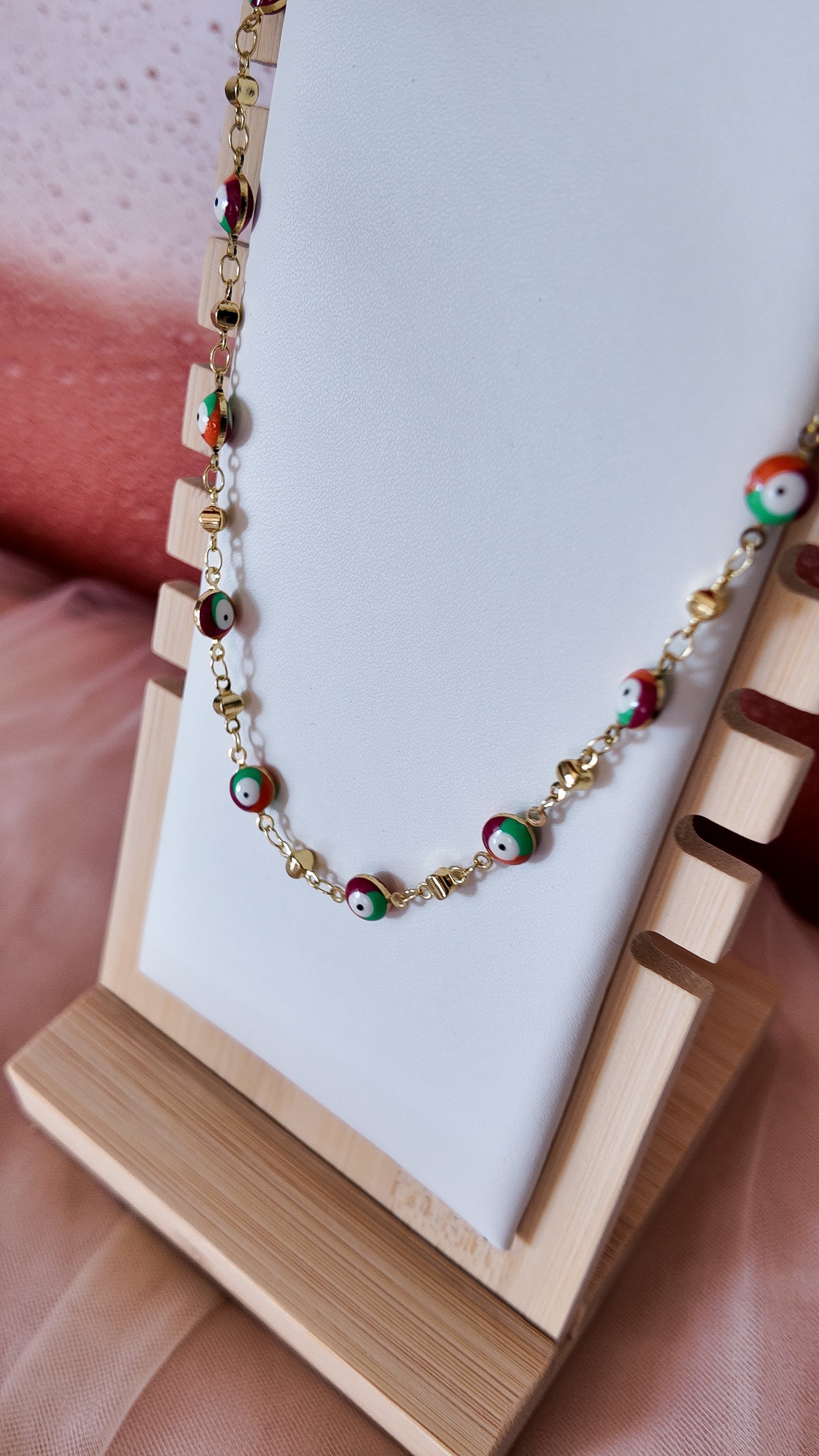 Necklace with colorful beads on a white card held by a hand