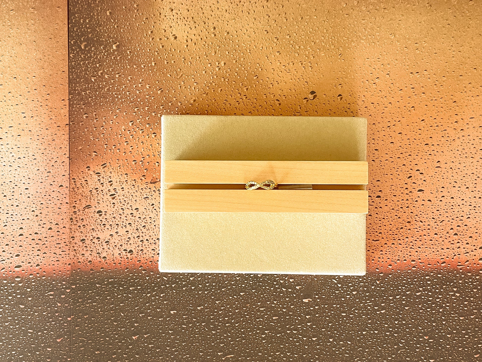Rectangular beige box with wooden accents on a textured brown surface