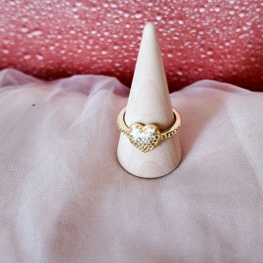 Ring on a cone-shaped stand with a pink textured background