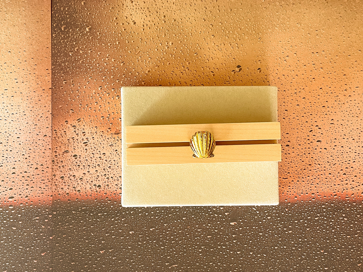 Decorative wall sconce with a gold finish on a textured wall.
